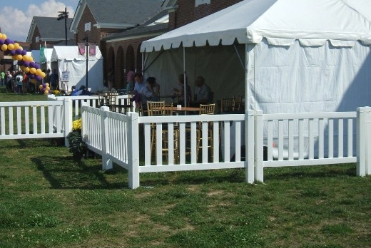Temporary fencing enclosing an outdoor event tent